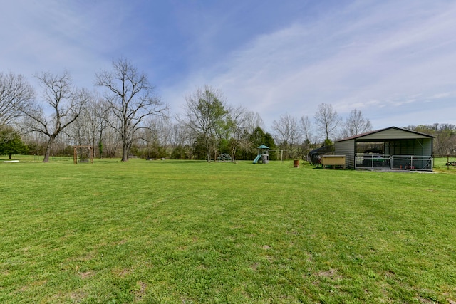 view of yard featuring a playground and an outbuilding