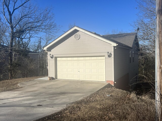 5058 Greenwood Dr, Merriam Woods, MO 65740 - view of property exterior with concrete driveway, a garage, and roof with shingles
