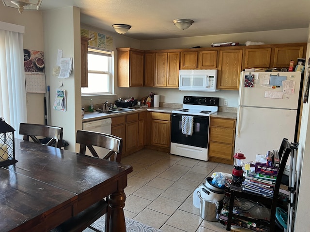 kitchen with white appliances, sink, and light tile patterned floors