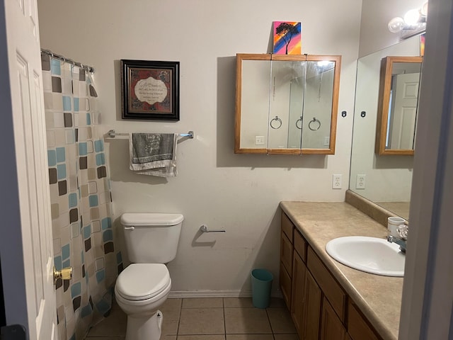 bathroom with toilet, vanity, and tile patterned floors