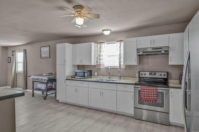 kitchen featuring a wealth of natural light, sink, white cabinets, and stainless steel appliances