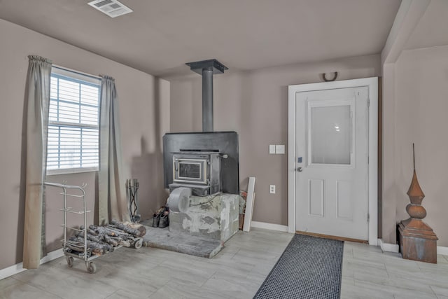 foyer entrance featuring a wood stove