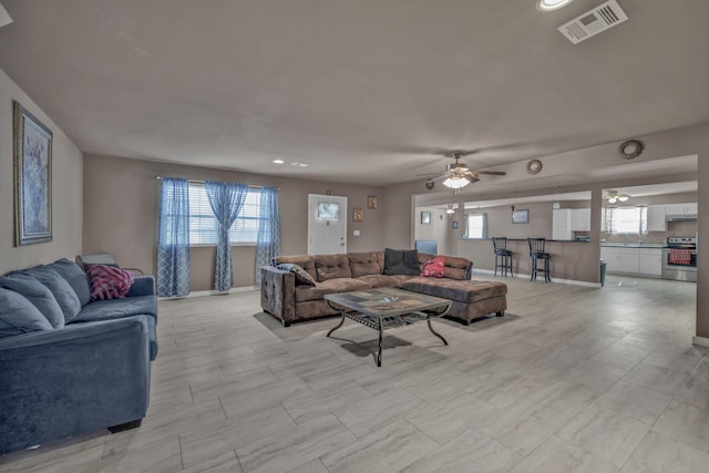 living room with ceiling fan and a healthy amount of sunlight