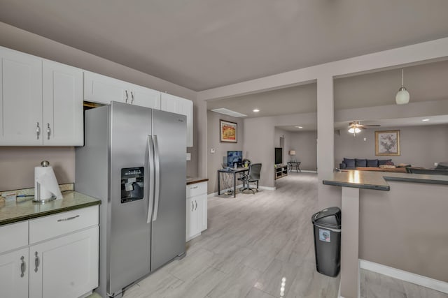 kitchen featuring hanging light fixtures, stainless steel fridge, white cabinetry, and ceiling fan