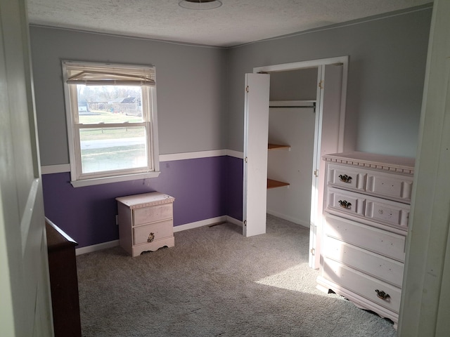 unfurnished bedroom with a textured ceiling and carpet floors