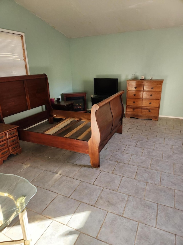 bedroom with light tile patterned floors and lofted ceiling