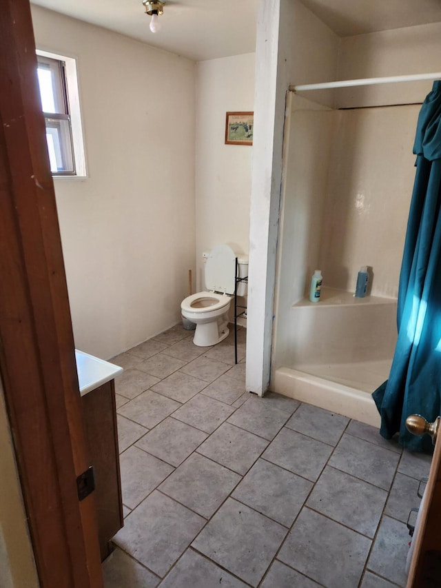 bathroom with tile patterned flooring, a shower with curtain, toilet, and vanity