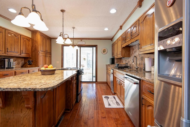 kitchen featuring an inviting chandelier, ornamental molding, a textured ceiling, dark hardwood / wood-style flooring, and stainless steel appliances