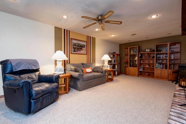 carpeted living room featuring a textured ceiling and ceiling fan