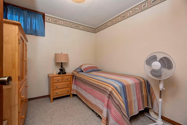 bedroom featuring light colored carpet and a textured ceiling