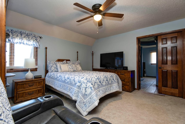 bedroom featuring light carpet, a textured ceiling, ceiling fan, and lofted ceiling