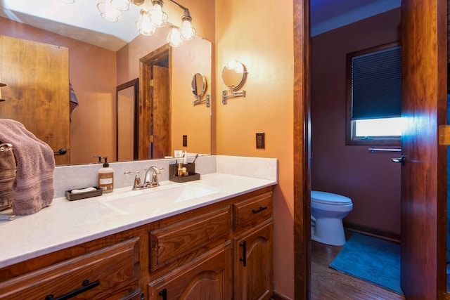 bathroom featuring wood-type flooring, vanity, and toilet