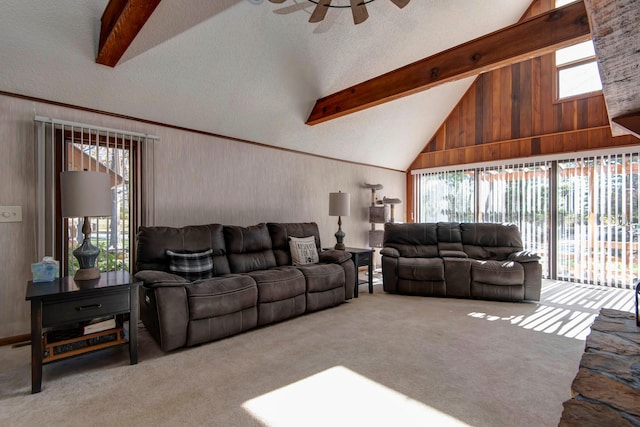 living room featuring ceiling fan, plenty of natural light, beamed ceiling, and light colored carpet