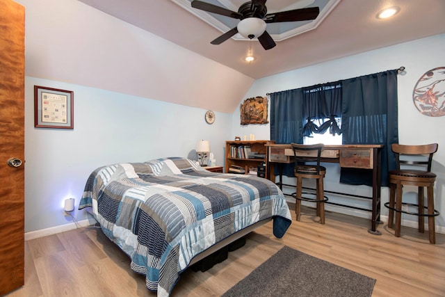 bedroom with hardwood / wood-style flooring, vaulted ceiling, and ceiling fan