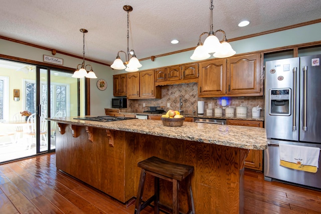 kitchen with a notable chandelier, crown molding, dark hardwood / wood-style floors, and appliances with stainless steel finishes