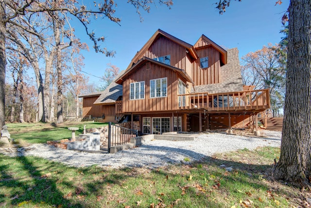 rear view of property with a deck and a yard