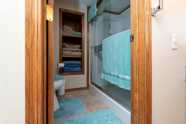 bathroom featuring tile patterned flooring, toilet, and walk in shower