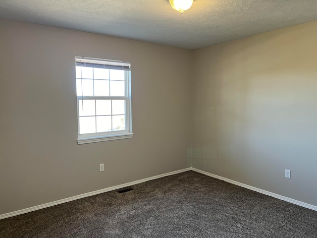 carpeted empty room with a textured ceiling