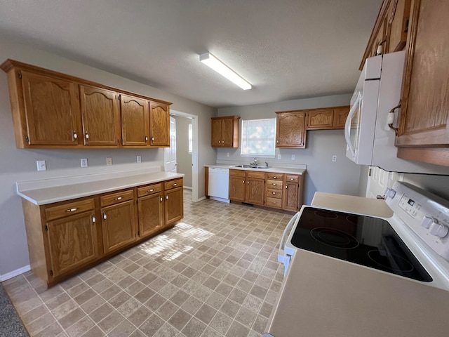 kitchen featuring a textured ceiling, white appliances, and sink