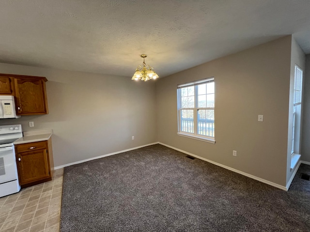 kitchen featuring pendant lighting, white appliances, light carpet, and a chandelier