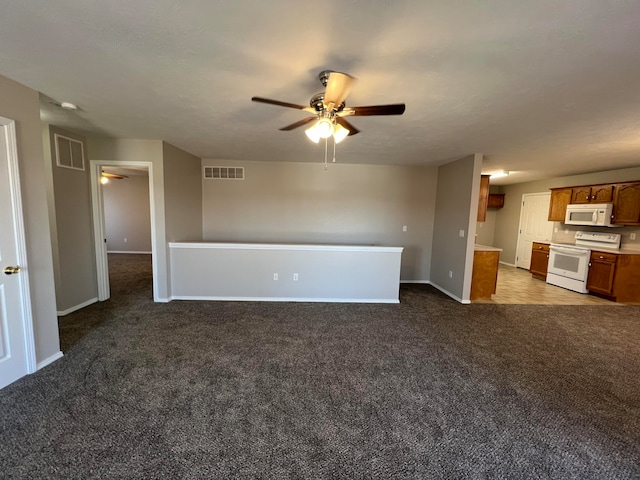 unfurnished living room featuring dark colored carpet and ceiling fan