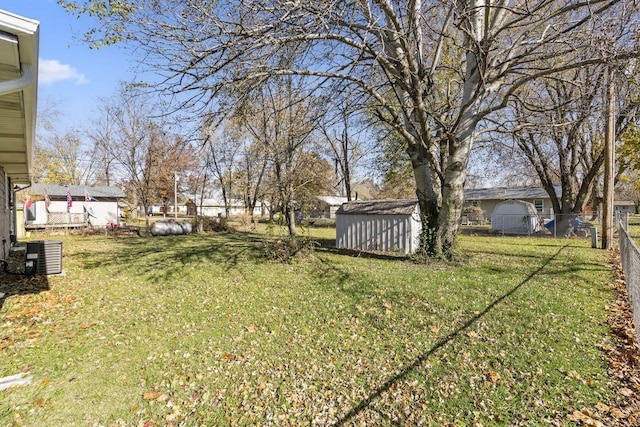 view of yard with central AC unit and a storage shed