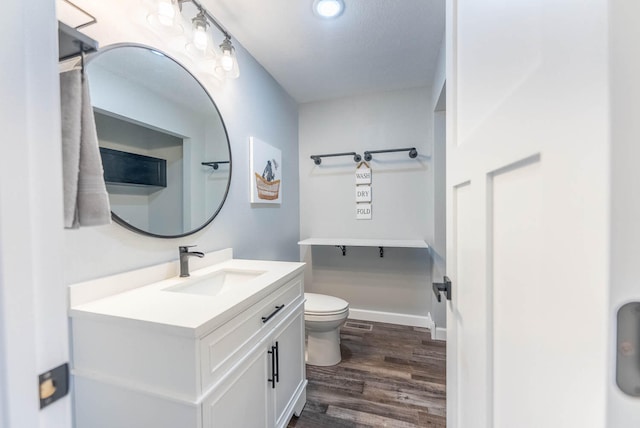 bathroom with hardwood / wood-style floors, vanity, and toilet