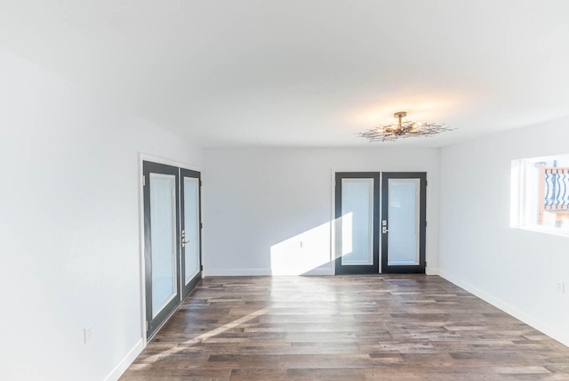 spare room with dark wood-type flooring and french doors