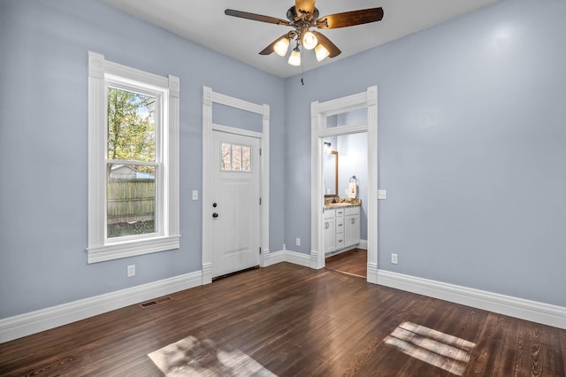 foyer entrance with ceiling fan and dark wood-type flooring