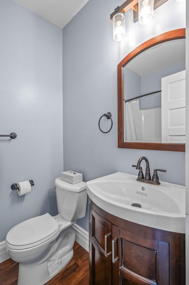 bathroom with vanity, hardwood / wood-style flooring, toilet, and curtained shower