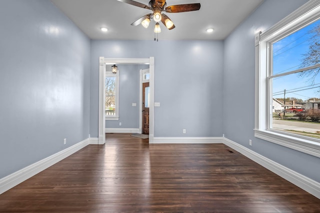 unfurnished room with dark hardwood / wood-style floors, a wealth of natural light, and ceiling fan