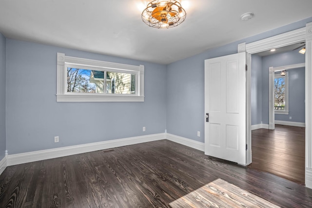 unfurnished bedroom with multiple windows and dark hardwood / wood-style floors