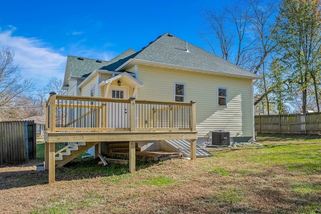 back of property with a yard, central AC unit, and a deck