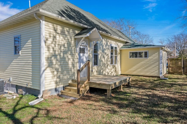 rear view of house with cooling unit, a yard, and a wooden deck