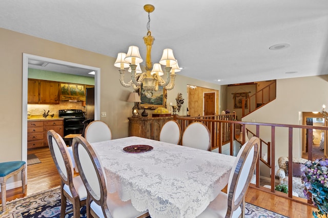 dining area with a notable chandelier and light wood-type flooring