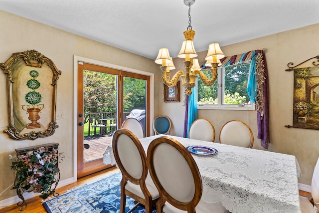 dining area with hardwood / wood-style flooring, an inviting chandelier, and plenty of natural light