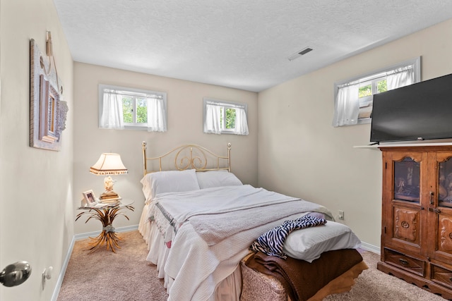 bedroom with light carpet and a textured ceiling