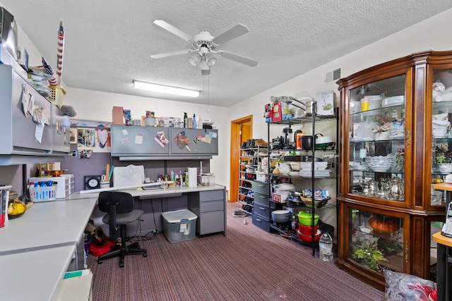 carpeted office space with ceiling fan and a textured ceiling