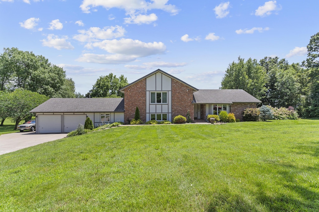 7316 E Loganwood Ln, Rogersville, MO 65742 - view of front of house with an attached garage, driveway, brick siding, and a front yard