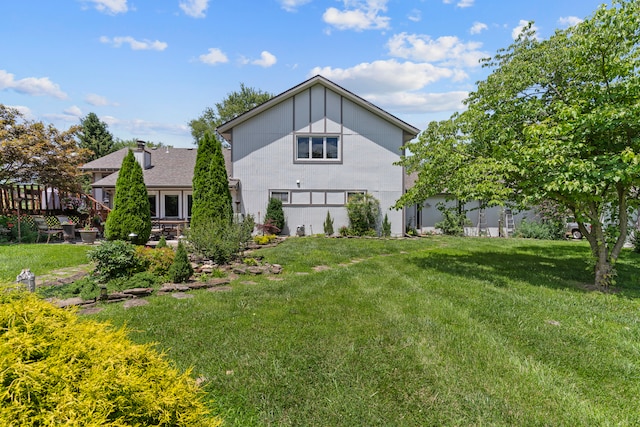 back of property with a yard and a wooden deck