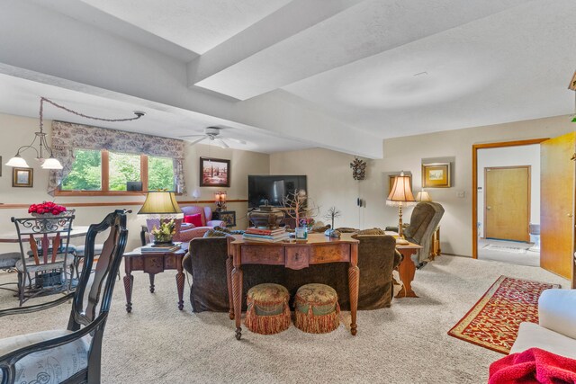 carpeted living room with ceiling fan and beam ceiling