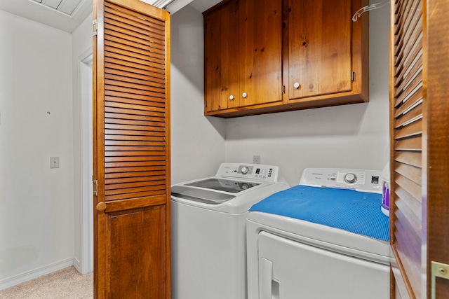 washroom featuring cabinets and washer and clothes dryer