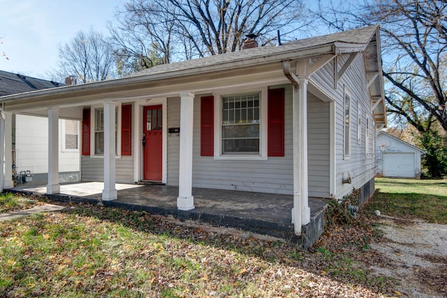 view of front facade featuring covered porch, a garage, and an outdoor structure