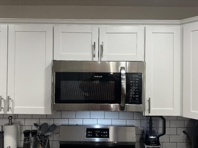 details featuring decorative backsplash, white cabinets, and stainless steel appliances