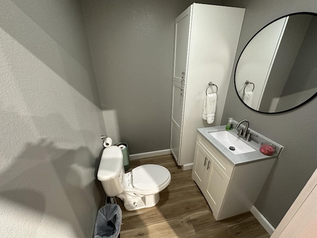 bathroom with toilet, vanity, and hardwood / wood-style flooring