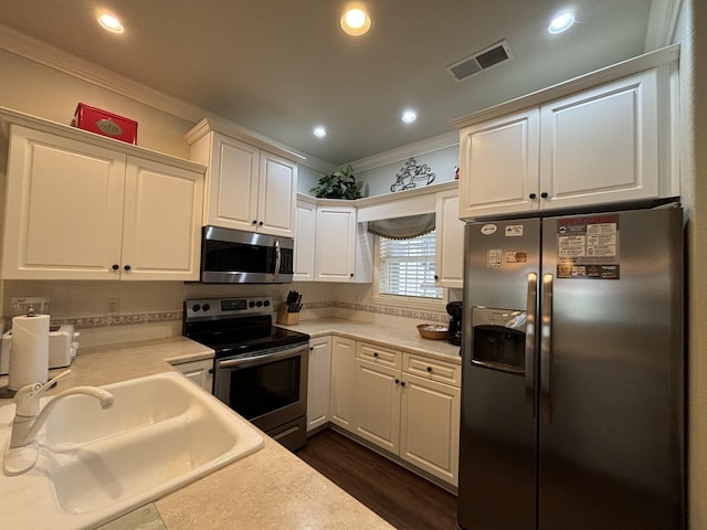 3830 Green Mountain Dr Unit 104, Branson, MO 65616 - kitchen featuring appliances with stainless steel finishes, ornamental molding, white cabinets, light countertops, and recessed lighting