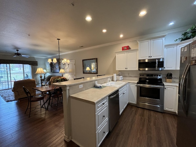 3830 Green Mountain Dr Unit 104, Branson, MO 65616 - kitchen with stainless steel appliances, a peninsula, crown molding, light countertops, and dark wood-type flooring
