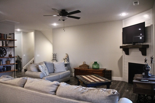 living room featuring ceiling fan and dark hardwood / wood-style flooring