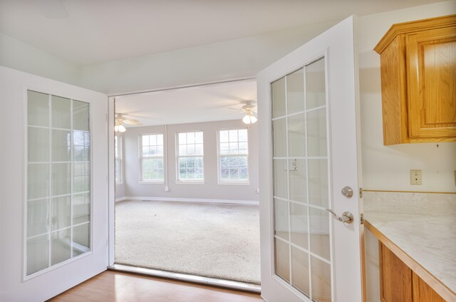 doorway featuring french doors, light hardwood / wood-style floors, and ceiling fan