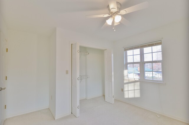 unfurnished bedroom featuring ceiling fan, a closet, and light colored carpet